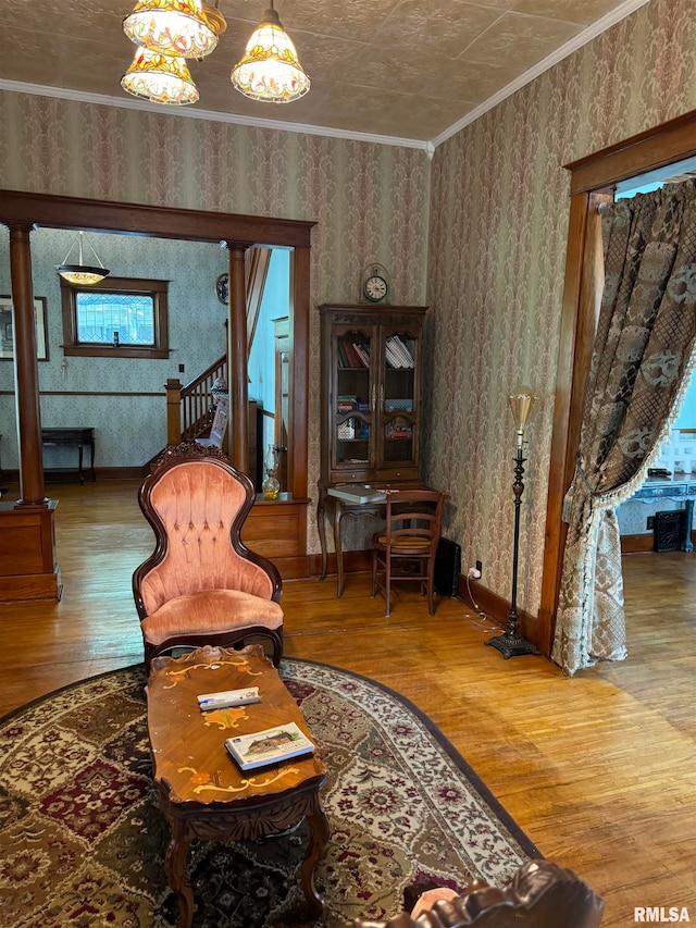 sitting room with hardwood / wood-style floors, a chandelier, and ornamental molding