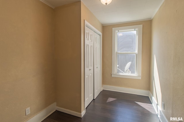 unfurnished bedroom featuring hardwood / wood-style floors, a closet, and ornamental molding