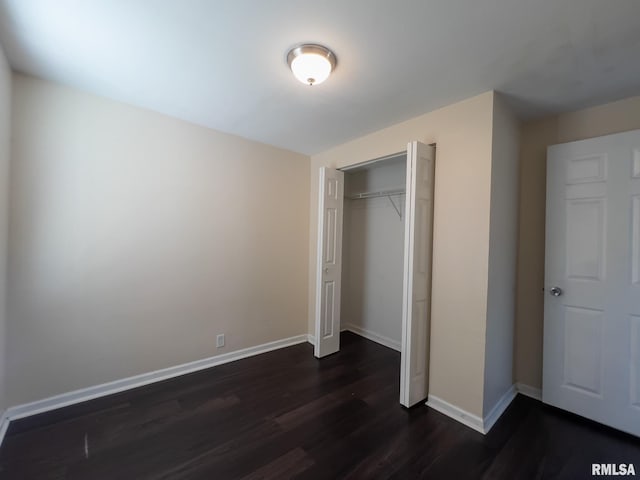 unfurnished bedroom with a closet and dark hardwood / wood-style flooring