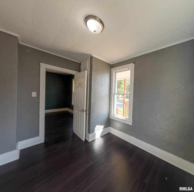 unfurnished room with ornamental molding and dark hardwood / wood-style floors