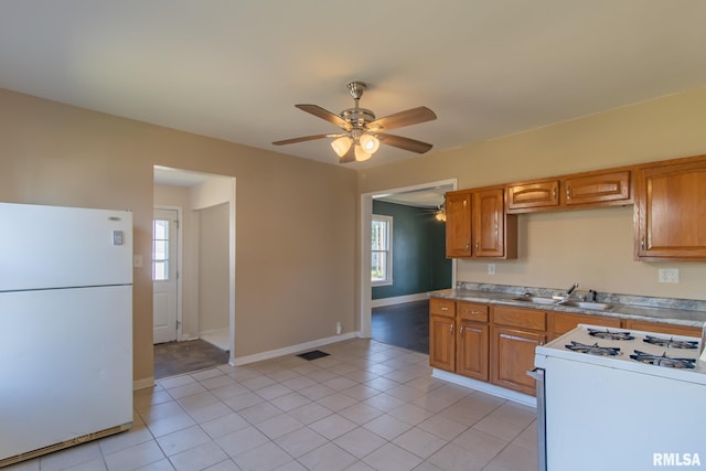 kitchen with a healthy amount of sunlight, ceiling fan, sink, and white appliances