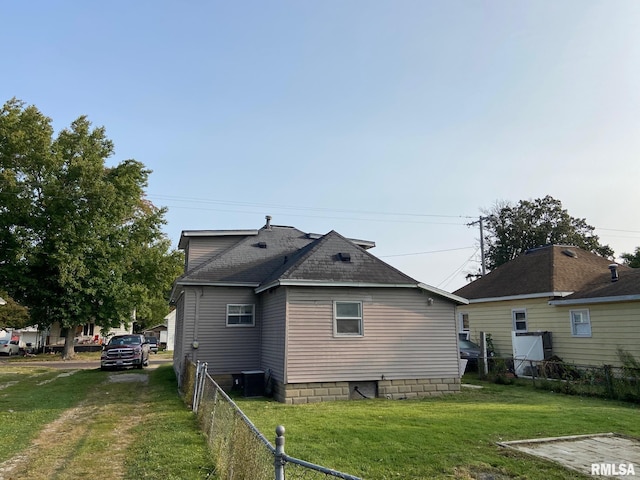 view of side of property with a lawn and central air condition unit