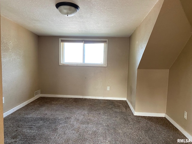 bonus room featuring a textured ceiling and carpet floors