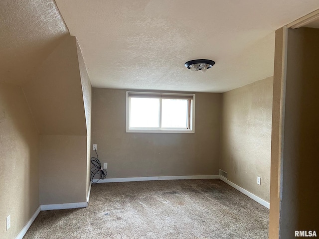 bonus room with a textured ceiling and carpet floors