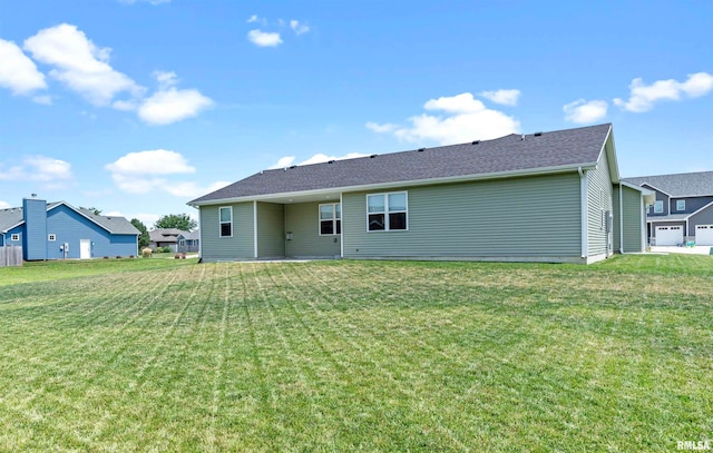 back of house featuring a garage and a yard