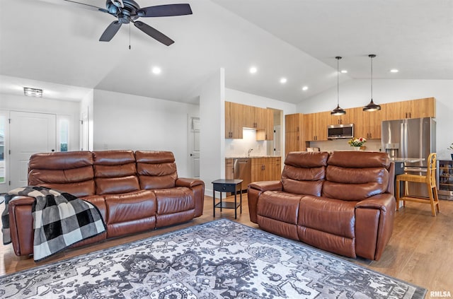 living room with high vaulted ceiling, ceiling fan, and light hardwood / wood-style floors