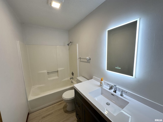 full bathroom with toilet, vanity, hardwood / wood-style floors, and washtub / shower combination