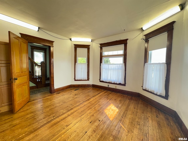 spare room featuring hardwood / wood-style flooring and a healthy amount of sunlight