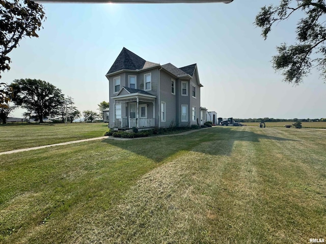 view of home's exterior featuring a lawn, a rural view, and a porch