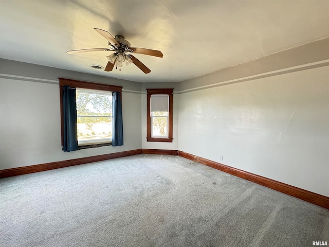 carpeted spare room featuring ceiling fan