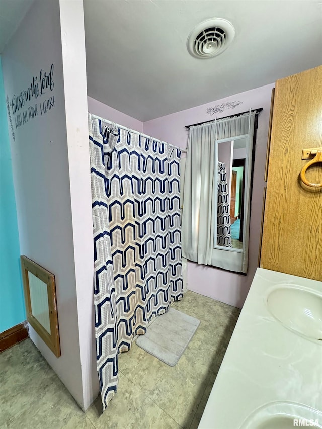 bathroom featuring walk in shower and vanity