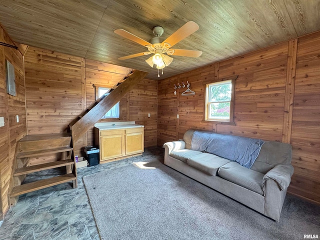 unfurnished living room featuring wood walls, ceiling fan, and wood ceiling