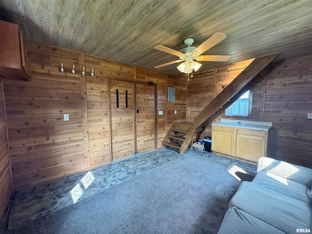 interior space featuring wood ceiling, ceiling fan, wooden walls, and carpet floors