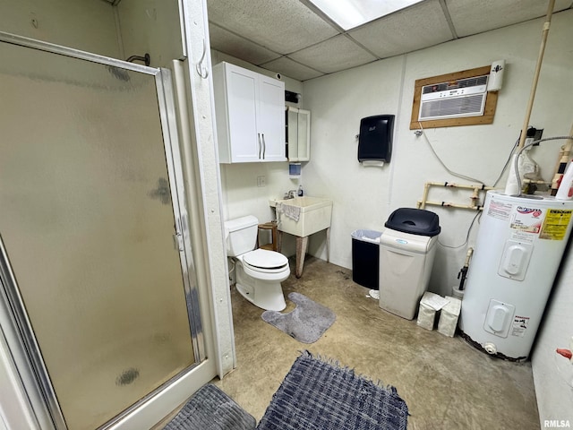 bathroom featuring toilet, concrete flooring, a drop ceiling, a shower with shower door, and water heater