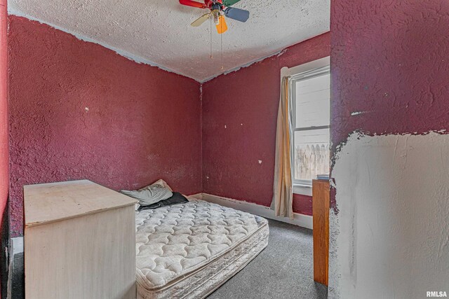 bedroom featuring a textured ceiling, ceiling fan, and carpet