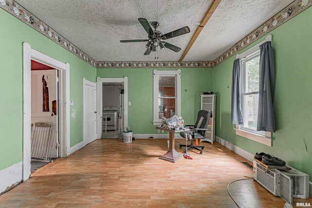 interior space featuring ceiling fan, light hardwood / wood-style floors, and a textured ceiling