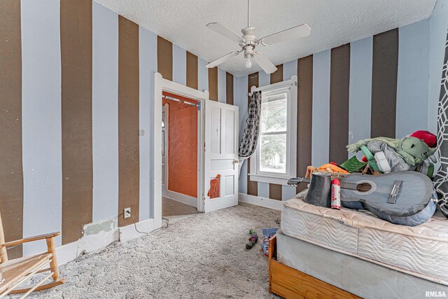 carpeted bedroom with ceiling fan and a textured ceiling