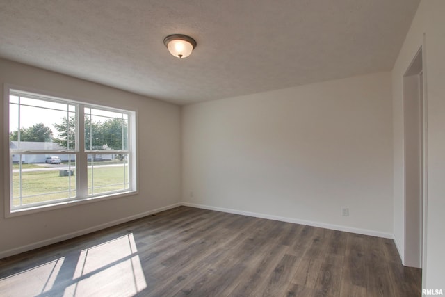 spare room with dark wood-type flooring and a textured ceiling