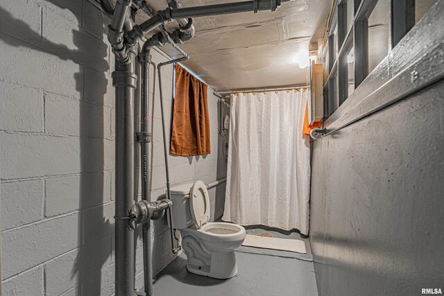 bathroom featuring toilet and curtained shower