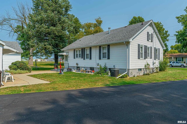 view of front of property with cooling unit and a front yard