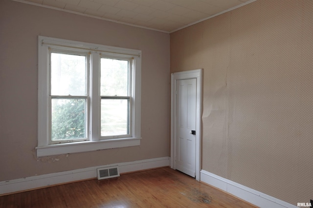 spare room featuring ornamental molding and light hardwood / wood-style floors