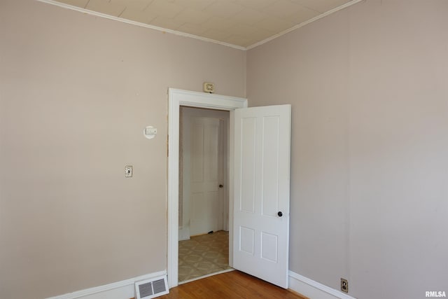 unfurnished room with wood-type flooring and ornamental molding