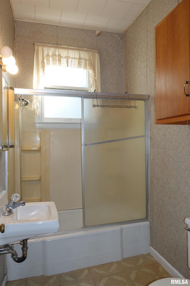 bathroom with enclosed tub / shower combo and sink