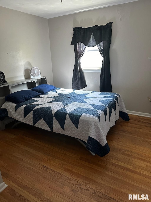 bedroom featuring baseboards and wood finished floors