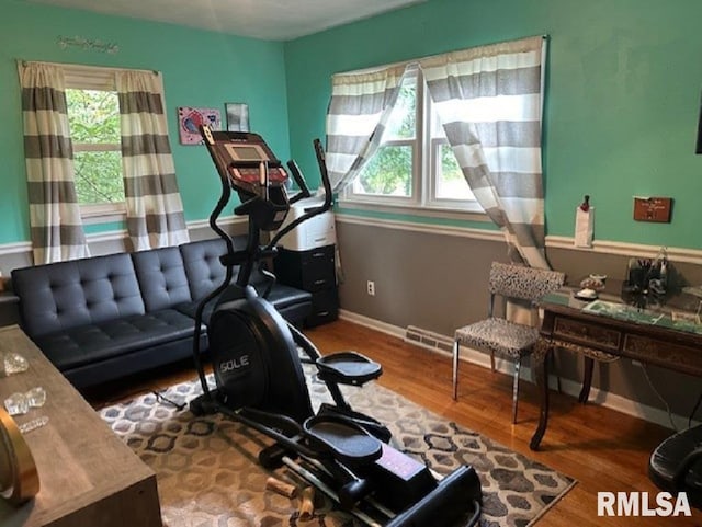 workout room with visible vents, baseboards, and wood finished floors