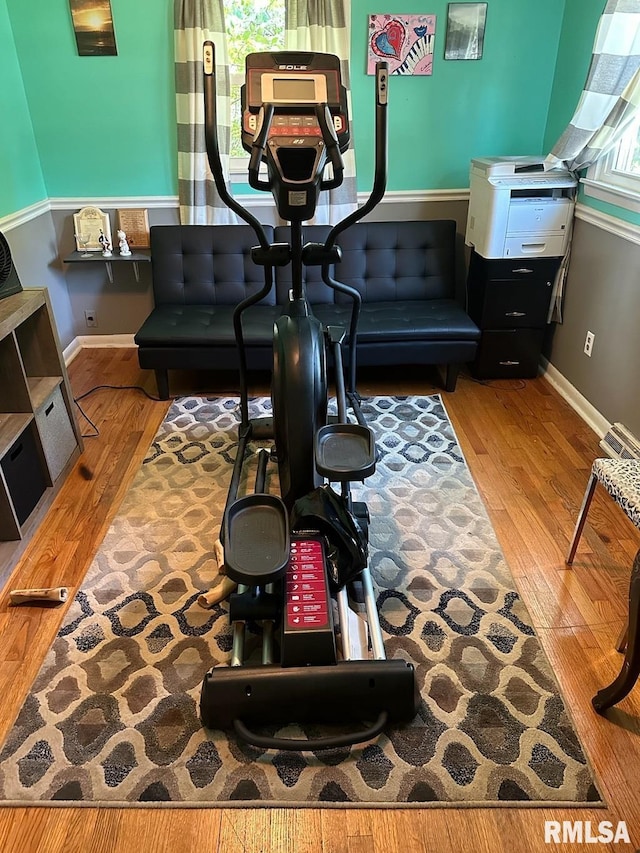 exercise area featuring wood finished floors and baseboards