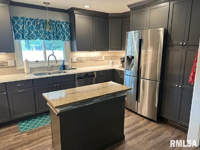 kitchen with gray cabinets, a sink, tasteful backsplash, dark wood finished floors, and appliances with stainless steel finishes