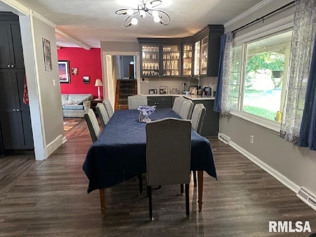 dining room with dark wood finished floors, baseboards, an inviting chandelier, and ornamental molding