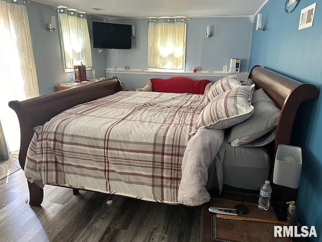 bedroom featuring wood finished floors and visible vents