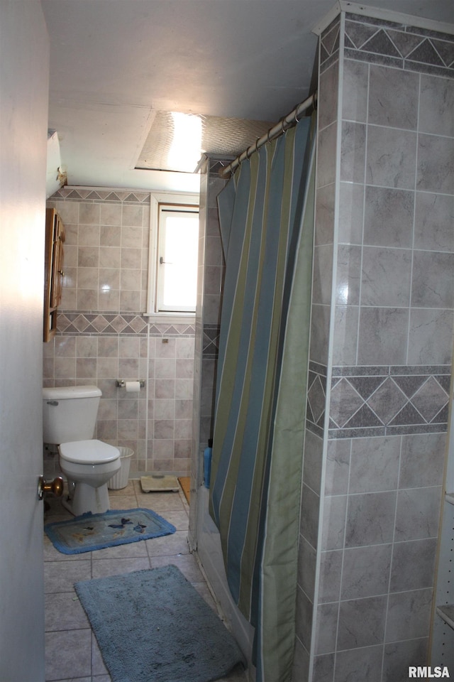 bathroom featuring tile walls, toilet, curtained shower, and tile patterned flooring