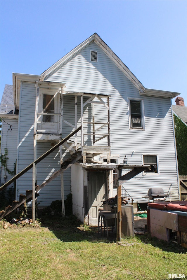 rear view of house featuring a lawn