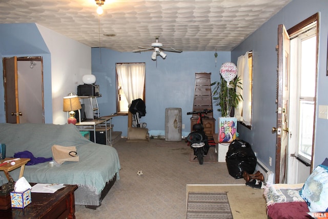 carpeted bedroom featuring ceiling fan and baseboard heating