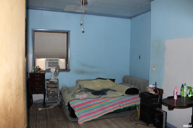 bedroom with cooling unit and wood-type flooring