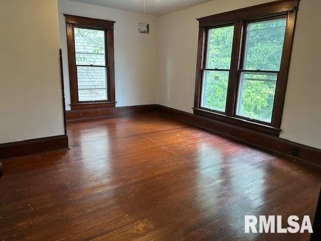 spare room featuring dark wood-type flooring and a wealth of natural light