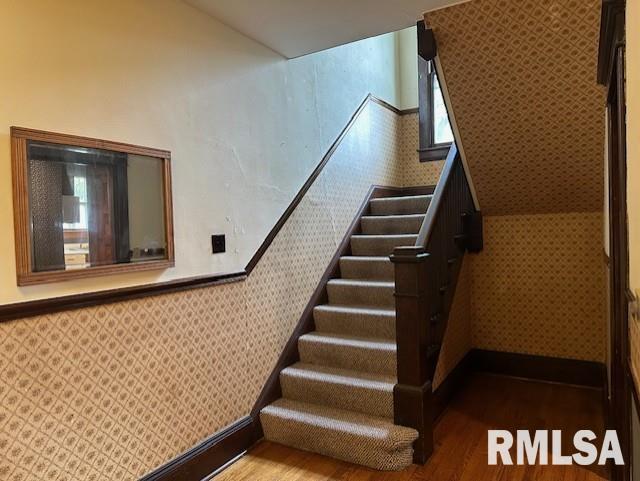 stairs featuring hardwood / wood-style floors