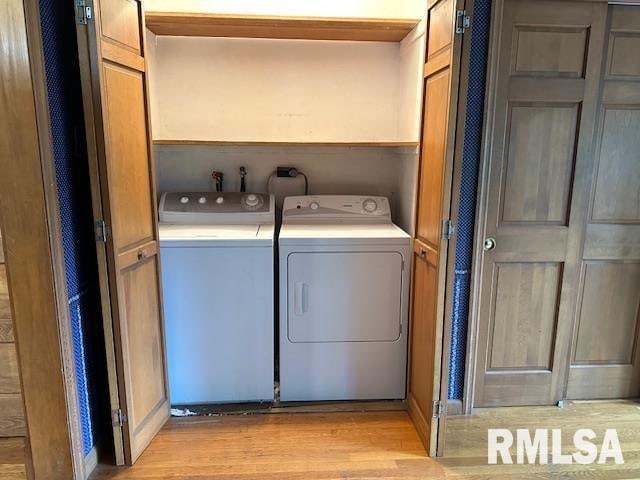 laundry room featuring washer and clothes dryer and light hardwood / wood-style flooring