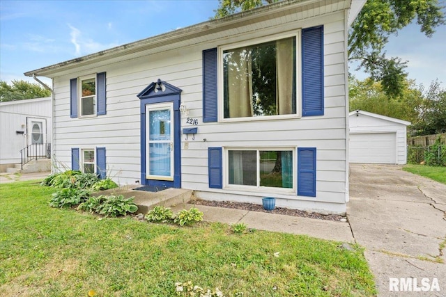 raised ranch featuring an outbuilding, a garage, and a front lawn