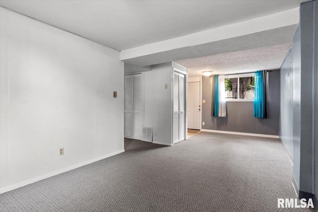 spare room featuring carpet flooring and a textured ceiling