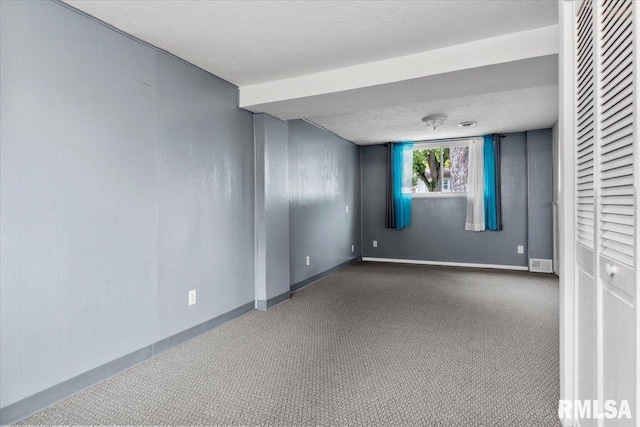 carpeted empty room featuring a textured ceiling