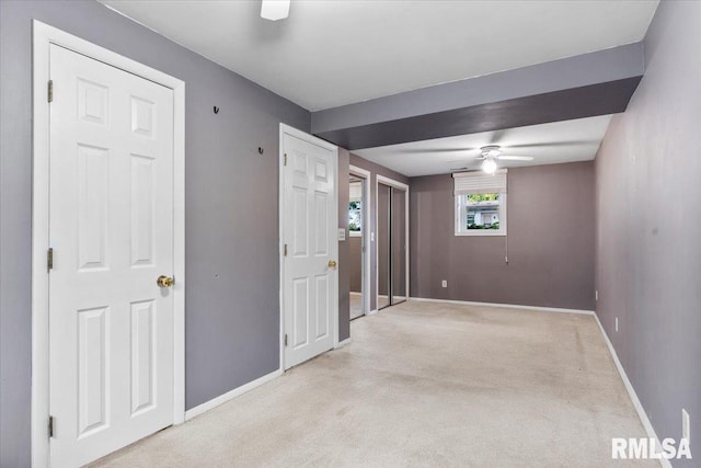 spare room featuring light colored carpet and ceiling fan