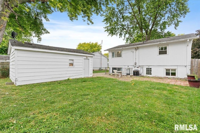 rear view of property with central AC and a yard