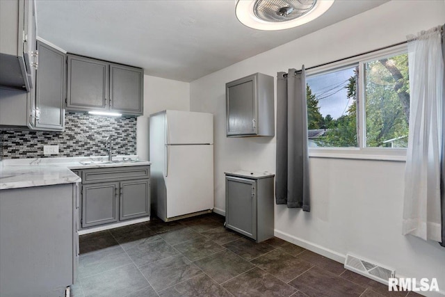 kitchen featuring white fridge, gray cabinets, plenty of natural light, and sink