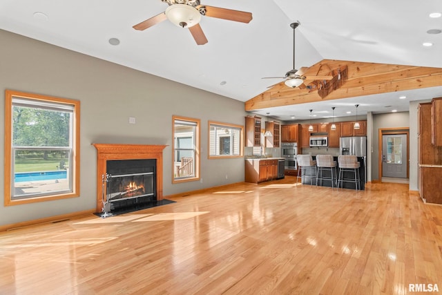 unfurnished living room featuring vaulted ceiling, ceiling fan, light hardwood / wood-style floors, and sink