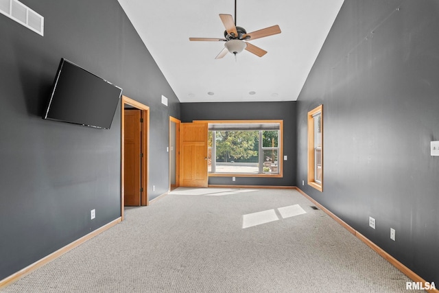 unfurnished bedroom with carpet flooring, ceiling fan, and high vaulted ceiling