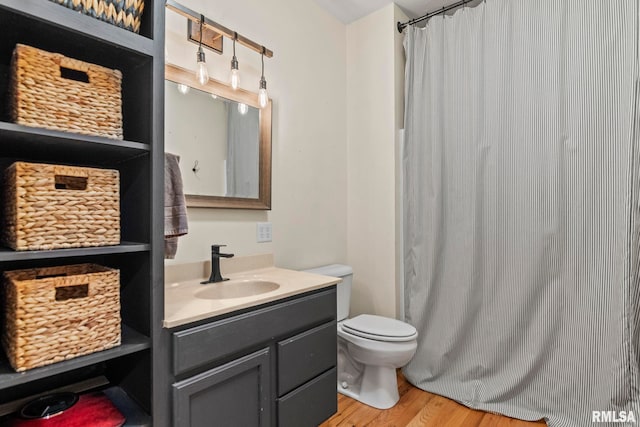 bathroom featuring wood-type flooring, vanity, and toilet