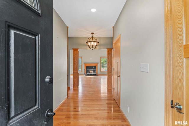 hall with an inviting chandelier and light hardwood / wood-style flooring